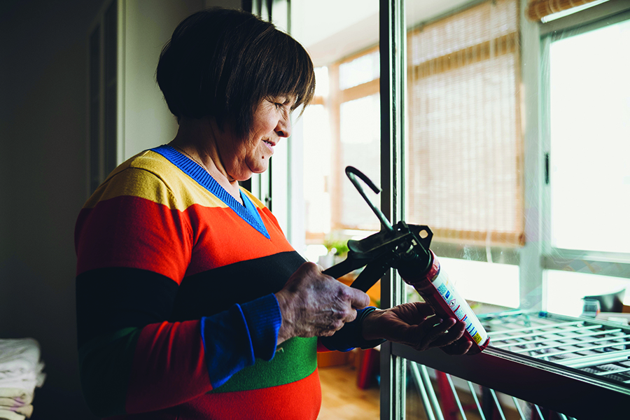 woman caulking window